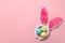 Funny headband with Easter bunny ears and dyed eggs on color background, flat lay.