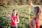 Funny hilarious moment. Girls friends blowing soap bubbles in park on summer day. Kids having fun outdoors. Authentic happy