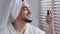 Funny Hispanic bearded Indian man with white bath towel on head in bathroom beauty procedures perfect skin care male