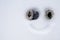 Funny homemade smiley face, with mittens instead of eyes and a painted smile on the snow. Creative idea. Copy space. Top