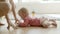 Funny infant crawling on floor from dad to mum and taking phone