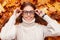 Funny joyful young hipster woman in a warm knitted sweater straightens fashionable glasses. Cheerful girl with a positive smile is