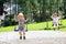 Funny kid boy having fun with chain swing on outdoor playground while being wet splashed with water