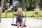 Funny kid boy having fun with chain swing on outdoor playground while being wet splashed with water