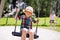 Funny kid boy having fun with chain swing on outdoor playground while being wet splashed with water