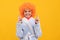 funny kid in curly clown wig. fancy child wear home bathrobe.