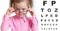 Funny kid putting on spectacles in ophthalmologist