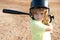 Funny kid up to bat at a baseball game. Close up child portrait.