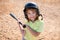 Funny kid up to bat at a baseball game. Close up child portrait.