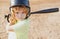 Funny kid up to bat at a baseball game. Close up child portrait.