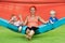 Funny kids with young mother chilling in swinging hammock