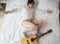 Funny lady flying with guitar on bed. Leisure, pajamas party. Soul and sound. Holiday