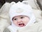 Funny laughing baby in a teddy bear hat in stroller