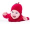 Funny laughing baby wearing knitted red apple hat