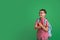 Funny, laughing schoolboy with glasses and holding Apple on green background