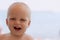 Funny laughing toddler on the beach looking at camera. Copy space