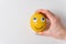 Funny lemon with eyes and smile on white background. Woman`s hand holding a lemon-smile