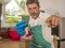 Funny lifestyle portrait of mid adult unhappy and stressed man in kitchen apron feeling frustrated and upset overwhelmed by