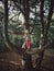 Funny little blonde Caucasian girl standing on large huge giant tree branch at sunset