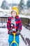 Funny little boy in colorful clothes happy about snow, outdoors