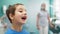 Funny Little Boy Considers his Damaged Baby Teeth in the Mirror in Dental Clinic