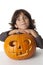 Funny Little boy leaning on a Halloween pumpkin