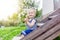 Funny little boy one year, sitting on the porch of a country house. Summer, childhood, nature