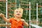 Funny little boy on playground with grid of football gate. playing child on sports ground