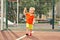 Funny little boy on playground with a grid of football gate. playing child on sports ground.