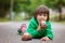 Funny little boy playing with car of chocolate, outdoor