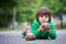 Funny little boy playing with car of chocolate, outdoor