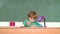Funny little boy pointing up on blackboard. School kids. Cheerful smiling child at the blackboard. Education. Little