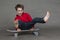 Funny little boy sitting on a vintage skateboard