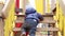 Funny little boy in a warm jacket and hat crawls, climbs and climbs up a wooden ladder on the Playground in the Park.