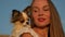 funny little chihuahua pet dog lying head on beautiful happy woman shoulder on blue sky background