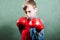 Funny little child with boxer gloves fighting looking dangerous