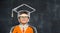 Funny little child genius. Kid boy in grad uniform and cap against blackboard. Back to school.