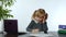 Funny little child girl boss manager emotionally talking on mobile phone, sitting at computer table