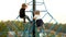 Funny little children climb on rope pyramid in city garden
