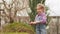 a funny little girl cuts bushes in the garden with large pruner.