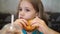 Funny little girl eats a burger in a cafe. fast food cafes.