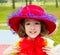 Funny little girl with fashion red hat and tulle bow