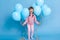 Funny little girl with helium balloons and shouts loudly, female child wearing rose jumper and pants, kid  over blue wall