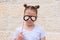 Funny little girl with paper glasses carnival mask having fun on white wall background.