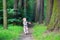 Funny little girl in rain boots walking in a park