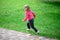 Funny little girl runing on green grass