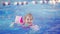 a funny little girl swims in inflatable armbands in a pool