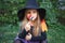 Funny little girl in witch costume eating Halloween candy outdoor