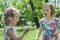 Funny little girls (sisters) blow on a dandelion.