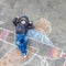 Funny little kid boy flying by a plane picture painting with colorful chalk. Creative leisure for children outdoors in